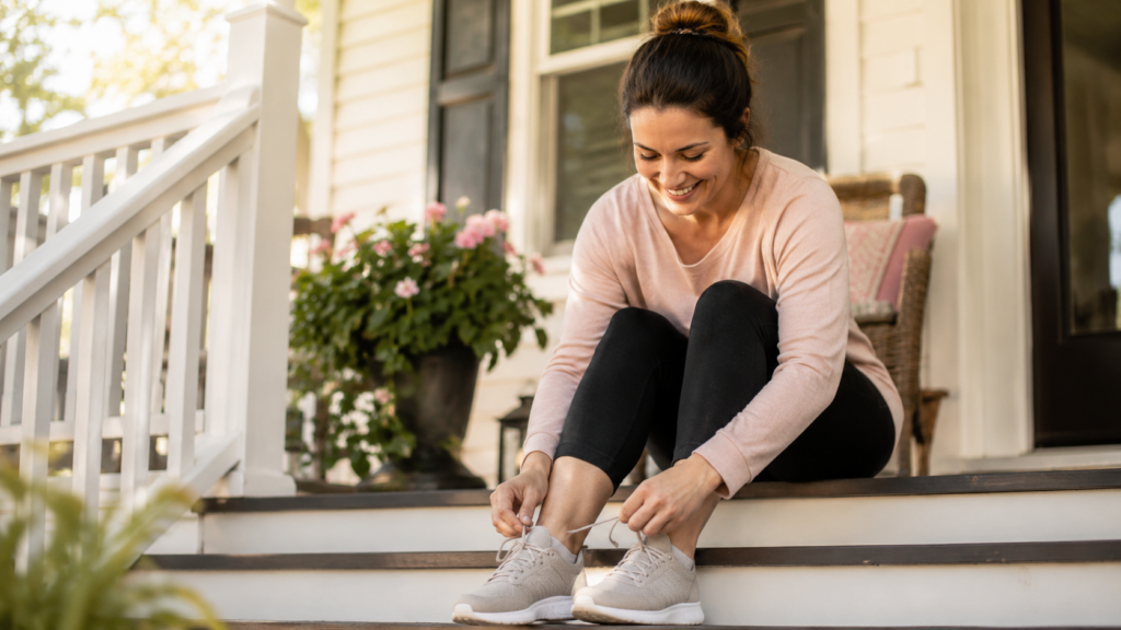 surrogate weight loss tips — warm portrait of a smiling woman lacing up sneakers for a walk near her home